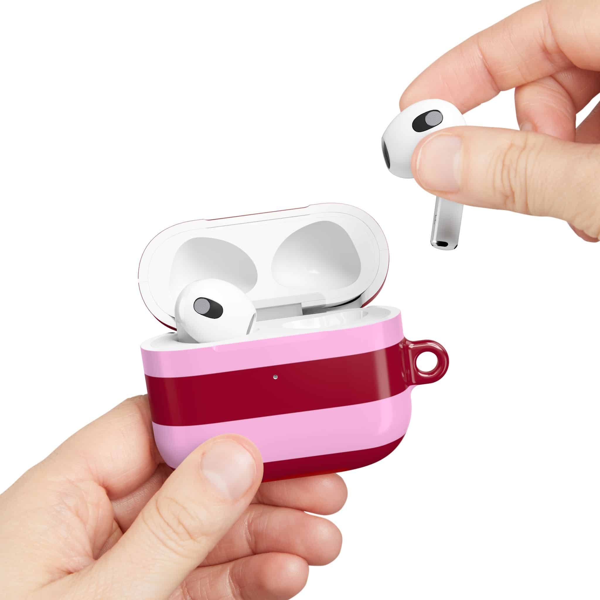 Wireless earbuds in a pink and red case, depicted with a hand placing an earbud into the case, showcasing stylish and high-quality audio accessories for trendy wireless listening.